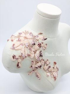 a white mannequin with pink flowers and sequins on it's back