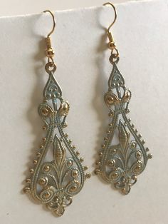 These earrings are made with a gold colored finding colored with blue patina. The earring hooks are gold colored. The earrings are very light weight and are perfect for any evening out. If you have any questions or concerns feel free to contact owner and designer at hannahsjeweltique@gmail.com Antique Gold Metal Earrings With Ear Wire, Antique Gold Metal Earrings For Pierced Ears, Vintage Gold Dangle Teardrop Earrings, Gold Metal Earrings With French Hook, Ornate Gold Nickel-free Earrings, Blue Brass Earrings For Pierced Ears, Vintage Gold Teardrop Plug Earrings, Antique Gold Metal Earrings With Filigree, Antique Gold Filigree Metal Earrings