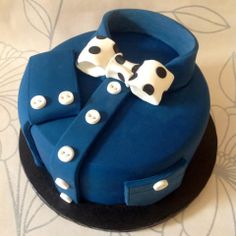 a blue cake with white polka dots and a bow tie