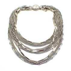 Beautiful multi strand necklace with 13 strands of silver tone chain. Some strands of the chain are curb link and some are bar link. They are graduated in length. Size: Shortest strand on the necklace is 13" long. Type: Pre Owned Mid Century Vintage from the 1960's. Condition: Great vintage condition with good working box clasp. Materials: Silver plated metal. Markings: Unsigned.