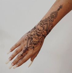 a woman's hand with a flower tattoo on the middle of her left arm