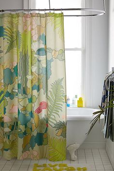 a bathroom with a bathtub, shower curtain and rug in front of the window