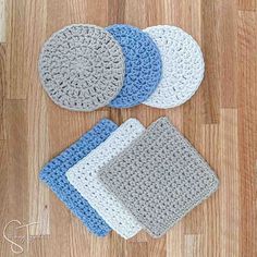 four crocheted coasters sitting on top of a wooden floor