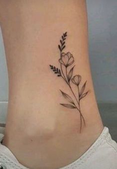 a small flower tattoo on the side of a woman's lower back ribcage