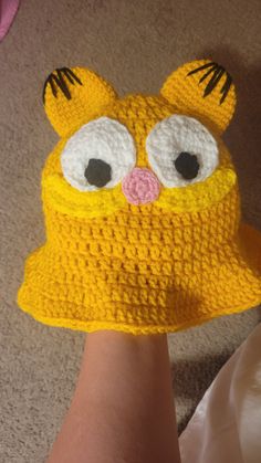 a person wearing a yellow crocheted hat with eyes