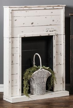 an old white fireplace with a basket on top