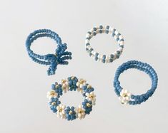 three bracelets and two rings with pearls on them sitting next to each other in front of a white background