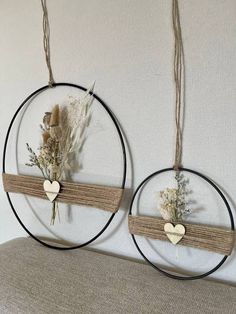 two circular metal wall hangings with flowers and hearts on the top one is black