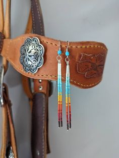 a brown leather belt with colorful beads hanging from it