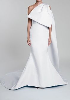 a woman wearing a white gown and cape