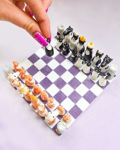 a person is playing chess on a purple and white checkered board with black pieces