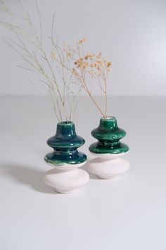 two vases with flowers in them sitting on a table