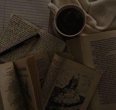 several open books and a cup of coffee on a table