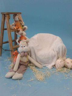 a stuffed animal laying on top of a chair next to other stuffed animals and toys