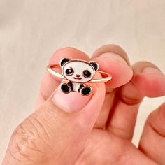 a person holding a ring with a panda bear on it