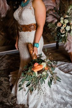 a woman in a white dress holding a bouquet and wearing a feather boa around her neck