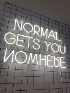 a neon sign that says normal gets you nomheie on the side of a wall