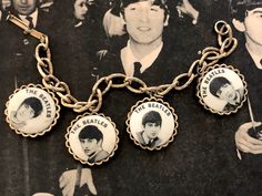 This vintage Beatles charm bracelet let is from 1964. It is a NEMS bracelet, so it is an authentic Beatles item licensed by their original management. The brace is a solid gold tone metal alloy, the face feel to be enameled. It measures 7 inches in length. As with all antiques, please understand this has been previously loved and some wear may be present. So please review pictures carefully and ask questions if there's something you would like to know more about. Please make sure you love it and Vintage Gold-tone Jewelry With Logo Charm, Vintage Gold Bracelet With Logo Charm, Vintage Gold Jewelry Souvenir, Adjustable Vintage Jubilee Charm Bracelet, Vintage Adjustable Charm Bracelet Collectible, Vintage Brass Charm Bracelets, Vintage Gold-tone Charm Bracelet As Gift, Adjustable Gold Charm Bracelet Collectible, Adjustable Gold Charm Bracelet