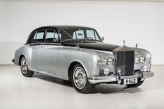 an old fashion car parked in a white room