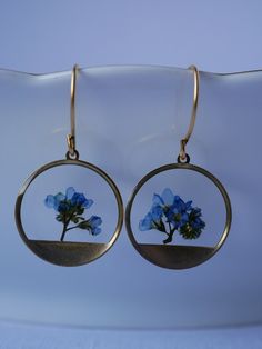 These small round brass frames that are evocative of the sun on the horizon hang from 24k gold plated ear hooks. Available in your choice of real preserved botanical: Queen Anne's Lace is a symbol of sanctuary The Daisy is a symbol of hope Forget-me-nots are known as a symbol of lasting friendship, love, and remembrance Materials are tarnish resistant. However, please see our care section for info on keeping your piece lovely for years to come. All materials are nickel and lead free. Ships in a Yellow Gold Circle Brass Earrings, Yellow Gold Circle Earrings In Brass, Nature-inspired Hoop Earrings As Gift, Handmade Nature-inspired Round Hoop Earrings, Nature-inspired Round Hoop Earrings For Gift, Dainty Recycled Gold Earrings, Pierced Round Recycled Gold Jewelry, Gold Brass Jewelry With Pressed Flowers, Minimalist Round Brass Earrings