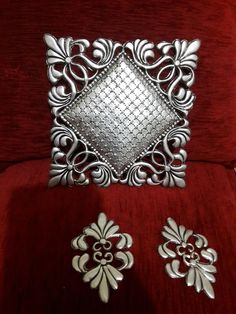 a red chair with some silver items on it's back and side pieces in the middle