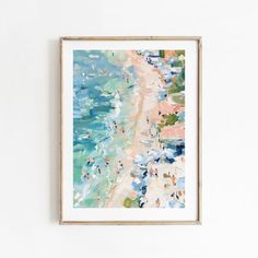 a painting hanging on the wall next to a white wall with an ocean scene in it