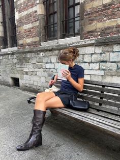 a woman sitting on a bench reading a book