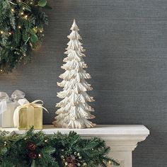 a white christmas tree sitting on top of a mantle