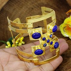 Lapis Lazuli Gemstone Bracelets- Gold Plated Brass- Handmade Bangle- Large Wrist Cuff Bracelet- Adjustable Bangle- Bridesmaid Gift- Vintage D E S C R I P T I O N : Item Code: EMS-1705 Metal: Brass Plating: Gold Plated Weight : 44.45 Gram Approx Stone Detail:- Lapis Lazuli Stone Size : 10 x 8 MM Approx , 4 MM Approx ❣❣ Handmade Item ❣❣ **Made to Order** » G EM S T O N E D E T A I L « **Gemstone structure may vary from the image as two gemstones do not have the same structure** If you want to see Handmade Brass Cuff Bracelet Shaped As Bangle, Adjustable Gemstone Cuff Bangle, Vintage Gemstone Cuff Bracelet Bangle, Spiritual Gemstone Cuff Bangle Bracelet, Bohemian Hand-wrapped Bangle Cuff Bracelet, Turquoise Bracelet Gold, Unique Bangle, Hammered Bangles, Simple Bangle