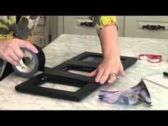 a woman is using scissors to cut out pieces of paper on a table top with other items around her