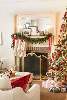 a living room decorated for christmas with stockings hanging on the fireplace mantel and wreaths