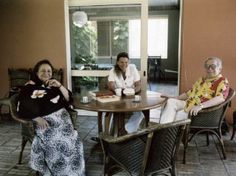 three women sitting at a table with food