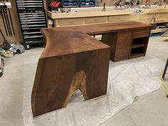 a wooden desk sitting on top of a table in a room filled with lots of tools