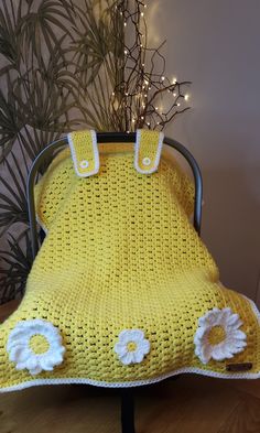 a yellow crocheted blanket sitting on top of a chair