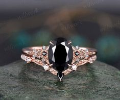 a black and white diamond ring on top of a rock