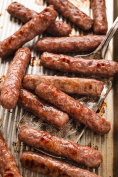 several sausages on a grill with a fork