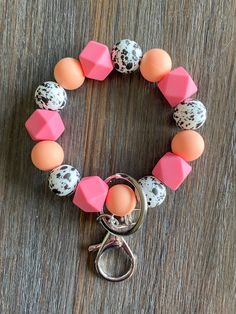 a pink, white and black beaded bracelet on a wooden table