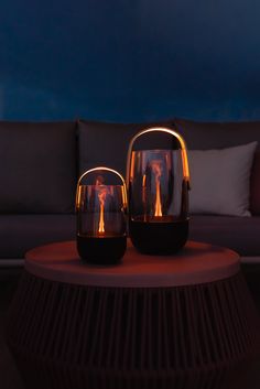 two vases sitting on top of a wooden table next to a couch in a living room