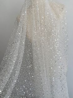 the back of a white dress with silver sequins