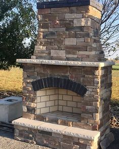 a brick oven sitting in the middle of a field