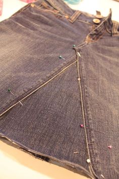 a pair of jeans that have been sewn together and are sitting on a table