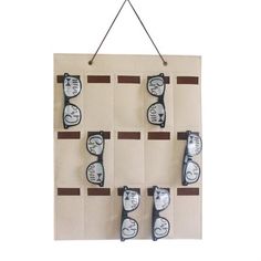 a wall hanging with glasses on it in front of a white background and brown stripes