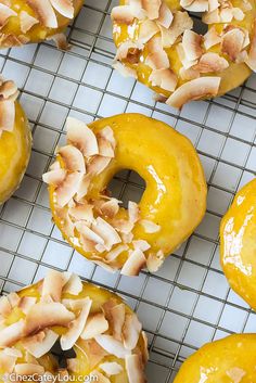 there are many doughnuts with toppings on the cooling rack in front of them