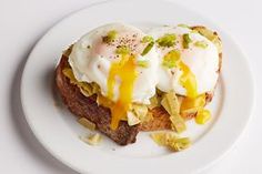 an open face sandwich topped with eggs and cheese