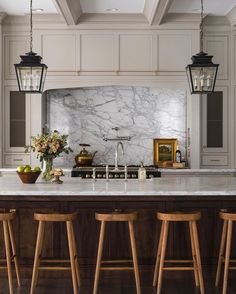 a kitchen with marble counter tops and wooden stools