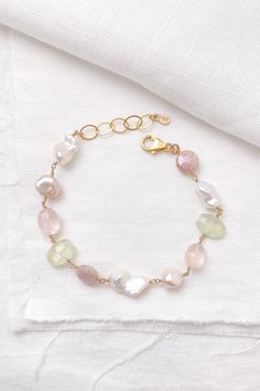 This handcrafted bracelet showcases a gentle mix of gemstones and pearls. It features ultra baroque white and mauve pink pearls that glow alongside faceted rose quartz and peach mystic moonstone. A touch of contrast is added by the spring green prehnite in this artisanal piece. Bracelet length: 8-9 inches (can be shortened on request) Materials: gold fill, freshwater pearls, rose quartz, mystic moonstone, prehnite Gift box included. Free shipping on US orders 30-day free returns Our artisan gems Elegant Adjustable Pastel Bracelets, Elegant Pastel Bracelets As Gift, Elegant Pastel Bracelets For Gifts, Multi Gemstone Bracelet, Pink Pearls, Gemstone Beads Jewelry, Handcrafted Bracelets, Mauve Pink, Birthstone Charms