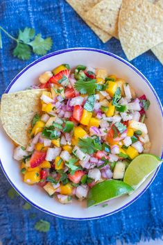 a white bowl filled with salsa and tortilla chips on top of a blue towel