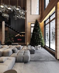 a living room filled with lots of couches and a christmas tree in the corner