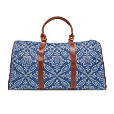 The Blue Batik travel bag is all about style. Made with high-grade waterproof nylon, it's a highly durable means of transferring your essentials wherever you go. With multiple compartments, a resilient carrying handle, and an adjustable shoulder strap, it's the perfect companion for all your adventures.  .: High-grade nylon material .: Microfiber PU leather top handle and binding .: One size: 20" × 12'' × 9" (50.8cm × 30.5cm × 23cm ) .: Brown PU leather handles and an adjustable shoulder strap .: Polyester lining .: Gold-colored zipper  .: All-over print Waterproof Travel Bag, Travel Duffel, Duffel Bags, Leather Handles, Duffel Bag, Travel Luggage, Leather Top, Leather Handle, Travel Bag