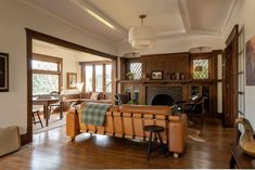 a living room filled with furniture and a fire place next to a wooden floored wall